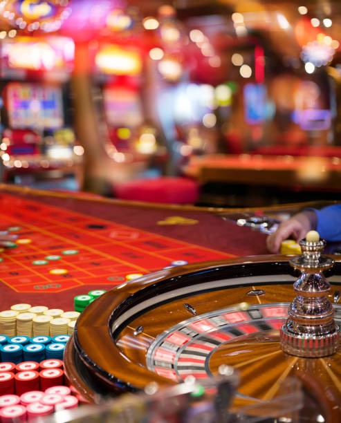Mobile phone showing Liga 1 match score and live roulette table simultaneously